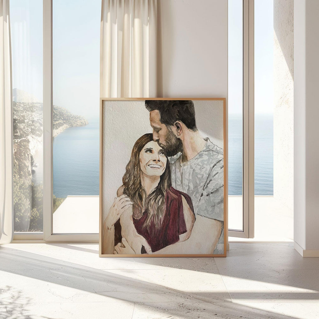 Framed watercolour couple portrait from a photo, leaning by a tall window with a sea view