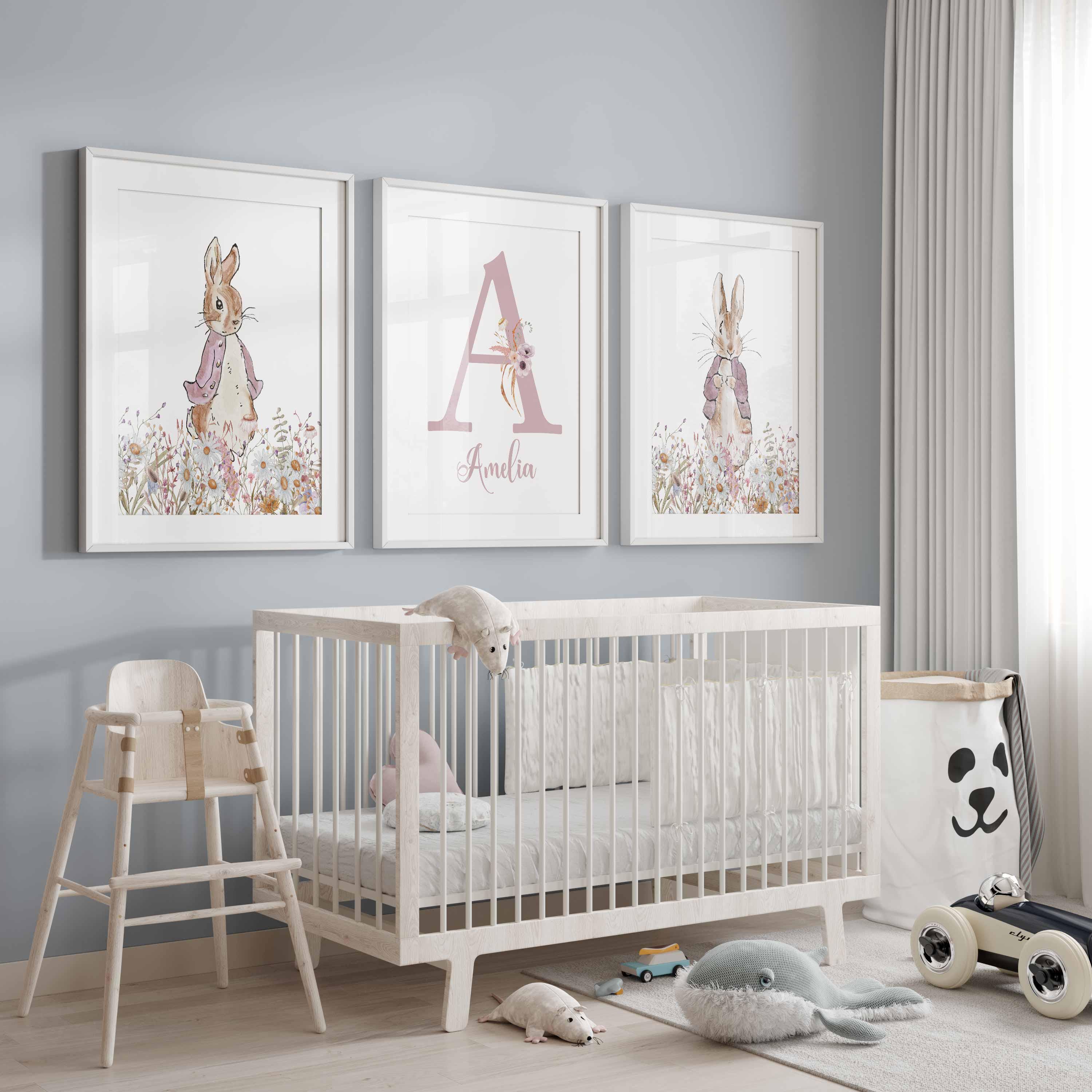 Two storybook rabbits and a pink initial above a white crib