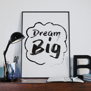 Dream big in black brush lettering inside a cloud, beside a desk lamp