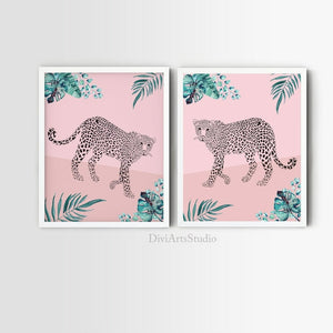 Two blush pink leopard prints with teal tropical leaves in white frames