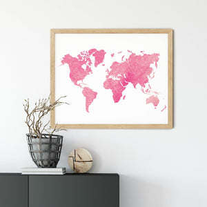 Pink watercolour world map in a wooden frame above a dark console