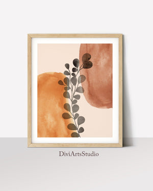Black eucalyptus sprig over terracotta shapes in a wooden frame