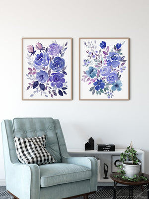 Two blue and violet floral bouquet prints above a pale blue armchair
