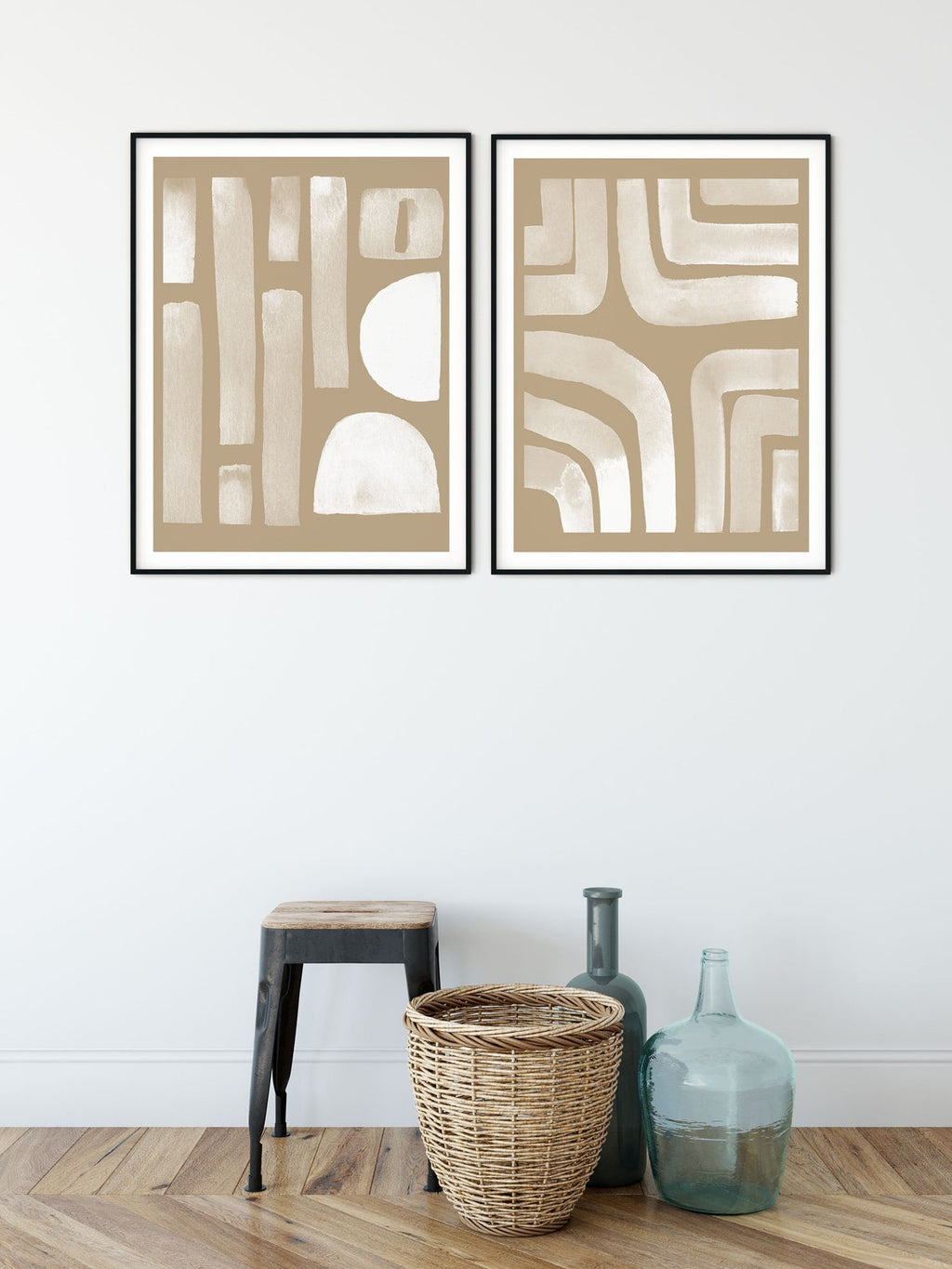 Neutral abstract set of 2 in black frames beside a stool and glass vases