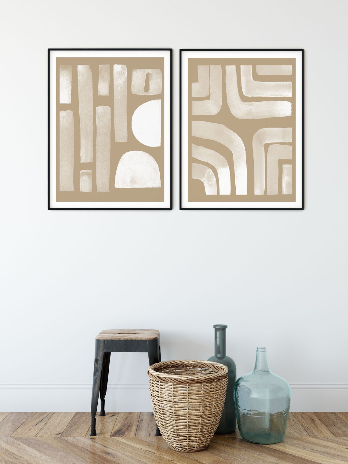 Neutral abstract set of 2 in black frames beside a stool and glass vases