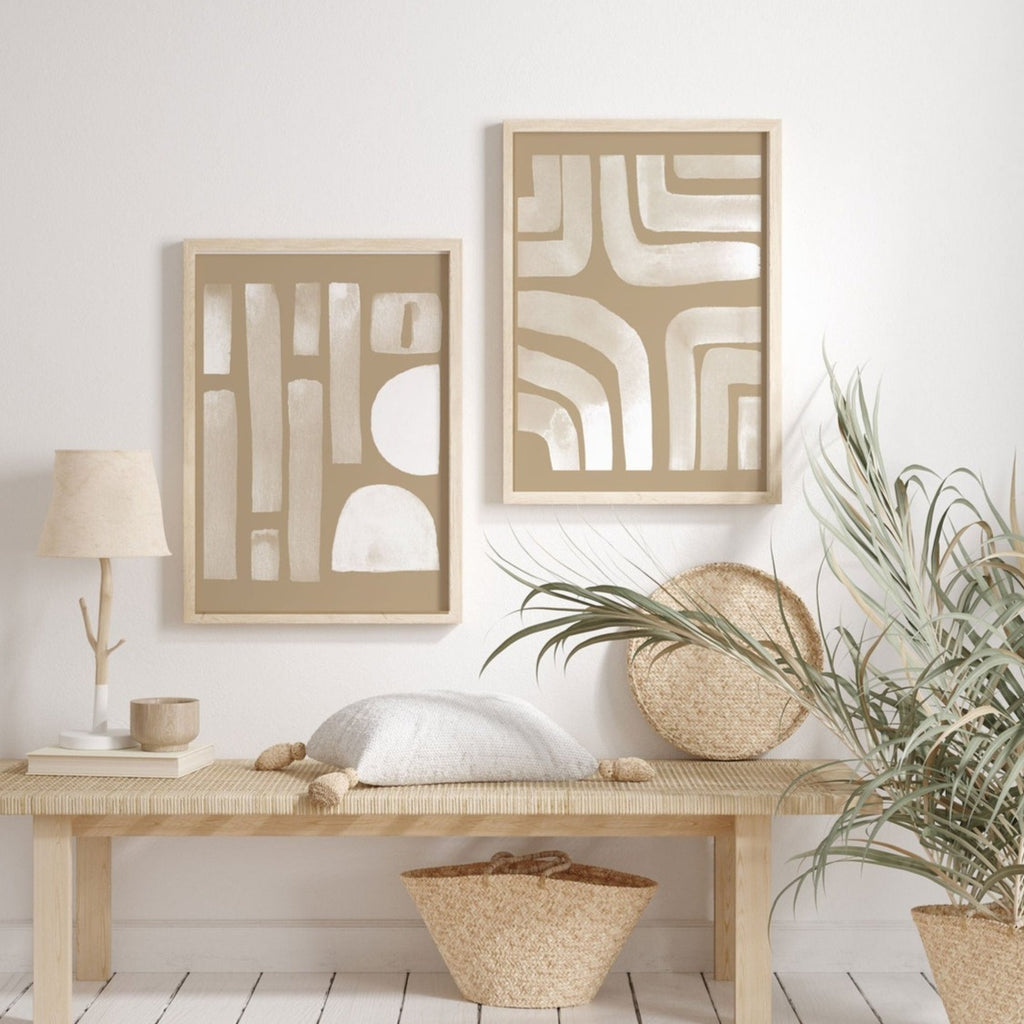 Two neutral abstract prints of beige arches and stripes above a wooden bench